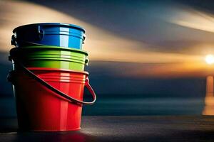 three colorful buckets sit on a table in front of the ocean. AI-Generated photo