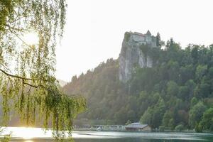 a castle sits on top of a hill overlooking a lake photo