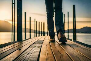 un persona caminando en un de madera muelle a puesta de sol. generado por ai foto