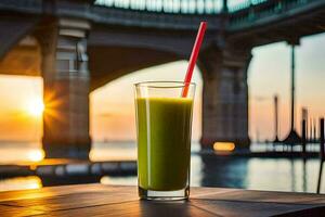 a glass of green juice with a red straw sitting on a table in front of a bridge. AI-Generated photo