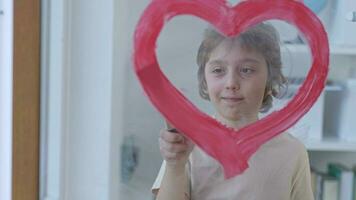 un niño pintura un corazón en un ventana vaso video