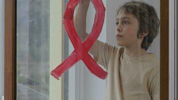 un niño con un rojo cinta en el ventana video