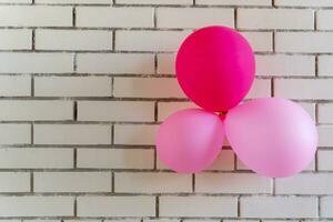 festivo rojo globos en un ladrillo pared antecedentes. concepto fiesta cumpleaños. foto