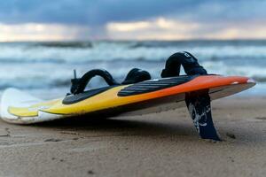 Sosnovy Bor, RUSSIA - OCTOBER 15, 2023  A surfboard lying on the sand of beach photo