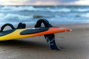 Sosnovy Bor, RUSSIA  OCTOBER 15, 2023 A surfboard lying on the sand of beach photo