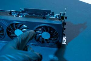 hand of a computer technician holds a modern powerful video game card photo