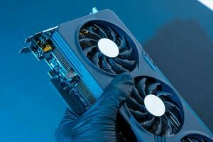 hand of a computer technician holds a modern powerful video game card photo