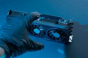 hand of a computer technician holds a modern powerful video game card photo