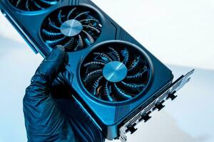 hand of a computer technician holds a modern powerful video game card photo