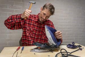 a funny and annoyed grief-stricken master repairs an electric iron photo