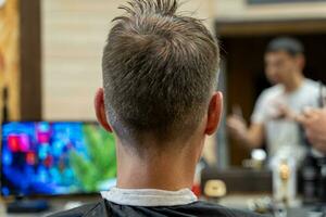 profesional peluquero cortes un del hombre cabello. visitar a el Barbero tienda foto