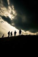 siluetas de personas en un colina con un dramático cielo. ai generado foto