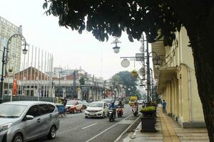 Bandung City, West Java, Indonesia. October 24 2023.  View of Asia Afrika Street in Bandung city. The daily business of city residents. Many vehicles passing by on the road photo