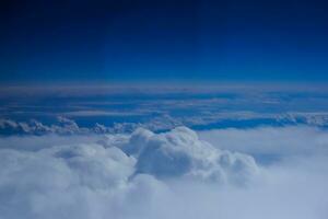 white clouds over a blue sky during a flight on summer vacation photo