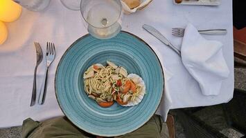 italiano espaguetis con un pescado salsa vendaje en un plato a un Mariscos restaurante foto