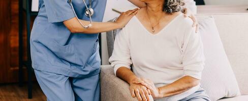 contento joven hembra enfermero proporcionar cuidado médico Servicio ayuda apoyo sonriente antiguo abuela a cuidados en el hogar médico visita, dama cuidador médico dar empatía animar retirado paciente sentar en sofá a hogar hospital foto