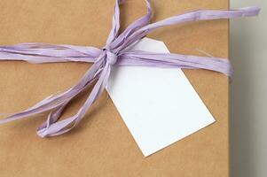 Mockup of a tag on a brown craft box with a ribbon. Space for text, copy space photo