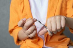 Manicure scissors in the hands of a child cut nails. Boy cutting his nails photo