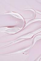 transparent gel texture on pink background. cosmetic cream stroke, face care gel. Creamy foundation or moisturizer photo
