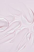 líquido gel cosmético mancha gotas textura en rosa antecedentes. cosmético frotis crema textura. piel cuidado producto carrera plano poner, crema con hialurónico ácido foto