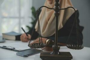 Business and lawyers discussing contract papers with brass scale on desk in office. Law, legal services, advice, justice and law concept picture with film grain effect photo