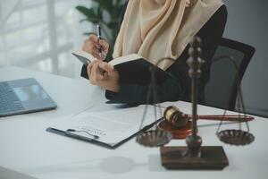 Business and lawyers discussing contract papers with brass scale on desk in office. Law, legal services, advice, justice and law concept picture with film grain effect photo