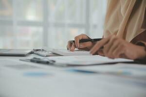 Businesswoman or accountant working Financial investment on calculator, calculate, analyze business and marketing growth on financial document data graph, Accounting, Economic, commercial concept. photo