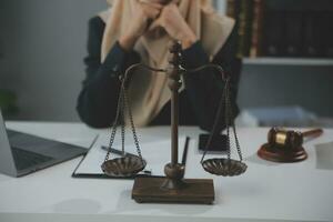 Business and lawyers discussing contract papers with brass scale on desk in office. Law, legal services, advice, justice and law concept picture with film grain effect photo