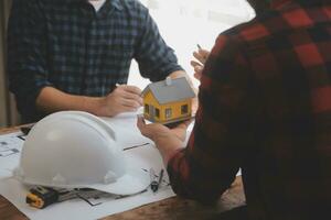 Close up of civil male engineer asian working on blueprint architectural project at construction site at desk in office. photo