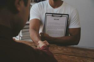 Close up view of job interview in office, focus on resume writing tips, employer reviewing good cv of prepared skilled applicant, recruiter considering application, hr manager making hiring decision photo