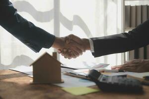 Real estate brokerage agent Deliver a sample of a model house to the customer, mortgage loan agreement Making lease and buy and sell house And contract home insurance mortgage loan concept photo