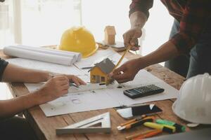 Close up of civil male engineer asian working on blueprint architectural project at construction site at desk in office. photo