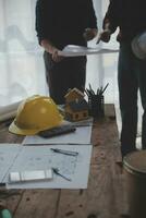 Close up of civil male engineer asian working on blueprint architectural project at construction site at desk in office. photo