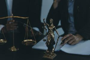 Business and lawyers discussing contract papers with brass scale on desk in office. Law, legal services, advice, justice and law concept picture with film grain effect photo