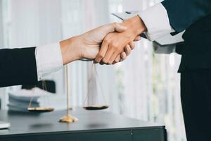 Businessman shaking hands to seal a deal with his partner lawyers or attorneys discussing a contract agreement photo