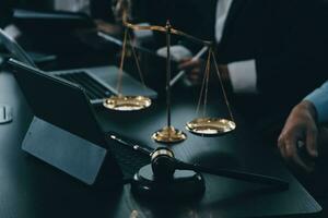 Business and lawyers discussing contract papers with brass scale on desk in office. Law, legal services, advice, justice and law concept picture with film grain effect photo