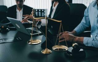 Business and lawyers discussing contract papers with brass scale on desk in office. Law, legal services, advice, justice and law concept picture with film grain effect photo