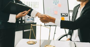 Businessman shaking hands to seal a deal with his partner lawyers or attorneys discussing a contract agreement photo