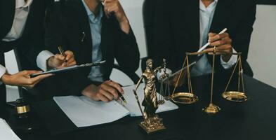 Business and lawyers discussing contract papers with brass scale on desk in office. Law, legal services, advice, justice and law concept picture with film grain effect photo