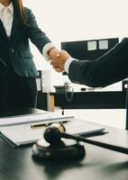 Businessman shaking hands to seal a deal with his partner lawyers or attorneys discussing a contract agreement photo