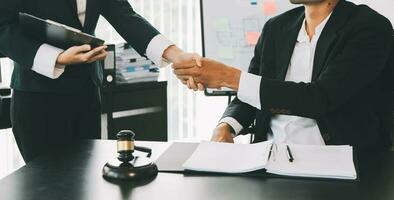 Businessman shaking hands to seal a deal with his partner lawyers or attorneys discussing a contract agreement photo