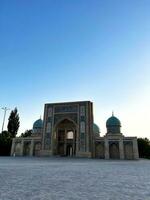 juntos con kukeldash madraza. mezquita en Taskent, uzbekistán entrada. maravilloso azul cúpulas arquitectónico puntos de referencia amplio zona forrado con Roca losas. hermosa mezquita islámico templo en azul cielo. foto