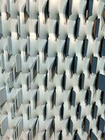 Textured mesh surface. Metallic modern lattice wall. Abstract gray blue background. Geometric Chopped grid. Vertical composition. Mesh geometric. Steel sheet grille panel pattern perspective view. photo