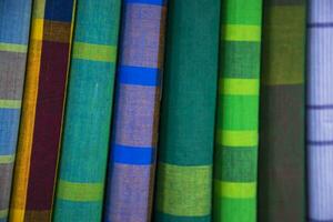 Multicolor Traditional Bangladeshi men's wear lungi folded on a rack in a store. Can be used as  pattern texture background wallpaper photo