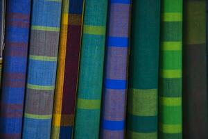 Multicolor Traditional Bangladeshi men's wear lungi folded on a rack in a store. Can be used as  pattern texture background wallpaper photo