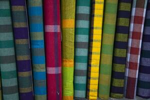 Multicolor Traditional Bangladeshi men's wear lungi folded on a rack in a store. Can be used as  pattern texture background wallpaper photo