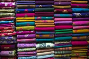 variedad artística colores de tono de sombra saris apilados en el estante de la tienda minorista para la venta foto