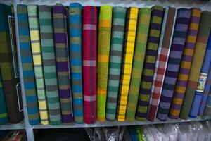 Multicolor Traditional Bangladeshi men's wear lungi folded on a rack in a store. Can be used as  pattern texture background wallpaper photo