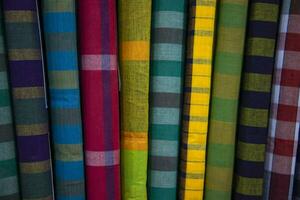 Multicolor Traditional Bangladeshi men's wear lungi folded on a rack in a store. Can be used as  pattern texture background wallpaper photo