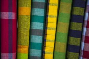 Multicolor Traditional Bangladeshi men's wear lungi folded on a rack in a store. Can be used as  pattern texture background wallpaper photo